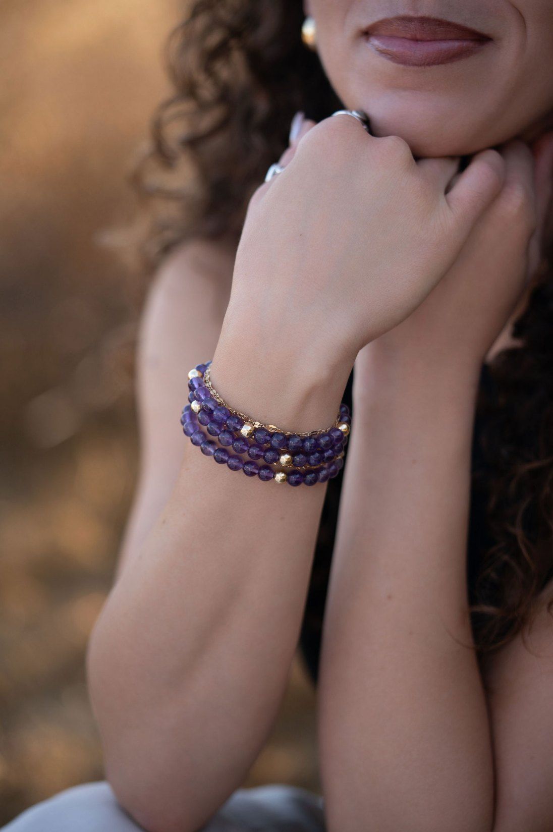 Amethyst and gold bracelets stacked on a wrist